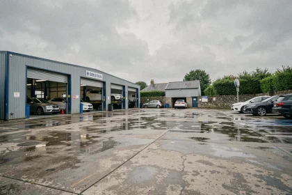 Vue d'ensemble de garages automobiles bretons avec mécaniciens au travail et voitures sur ponts élévateurs